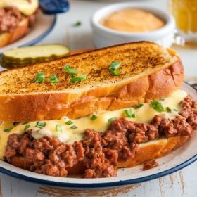 Homemade garlic bread sloppy joes garnished with fresh parsley and Parmesan cheese.