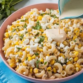 Close-up of zesty Mexican Street Corn Pasta Salad drizzled with tangy sauce, courtesy of Blackstone Recipes